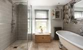 The tastefully curated family bathroom showing the spacious shower and enormous roll-top bath. - Thumbnail Image