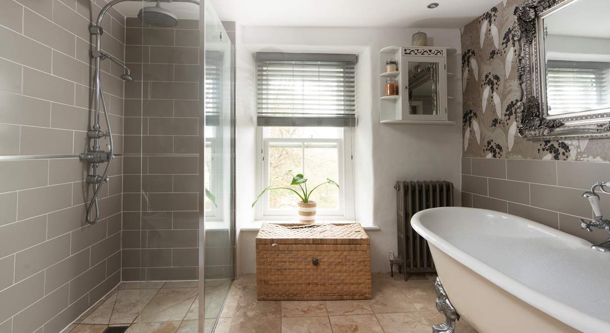 The tastefully curated family bathroom showing the spacious shower and enormous roll-top bath.