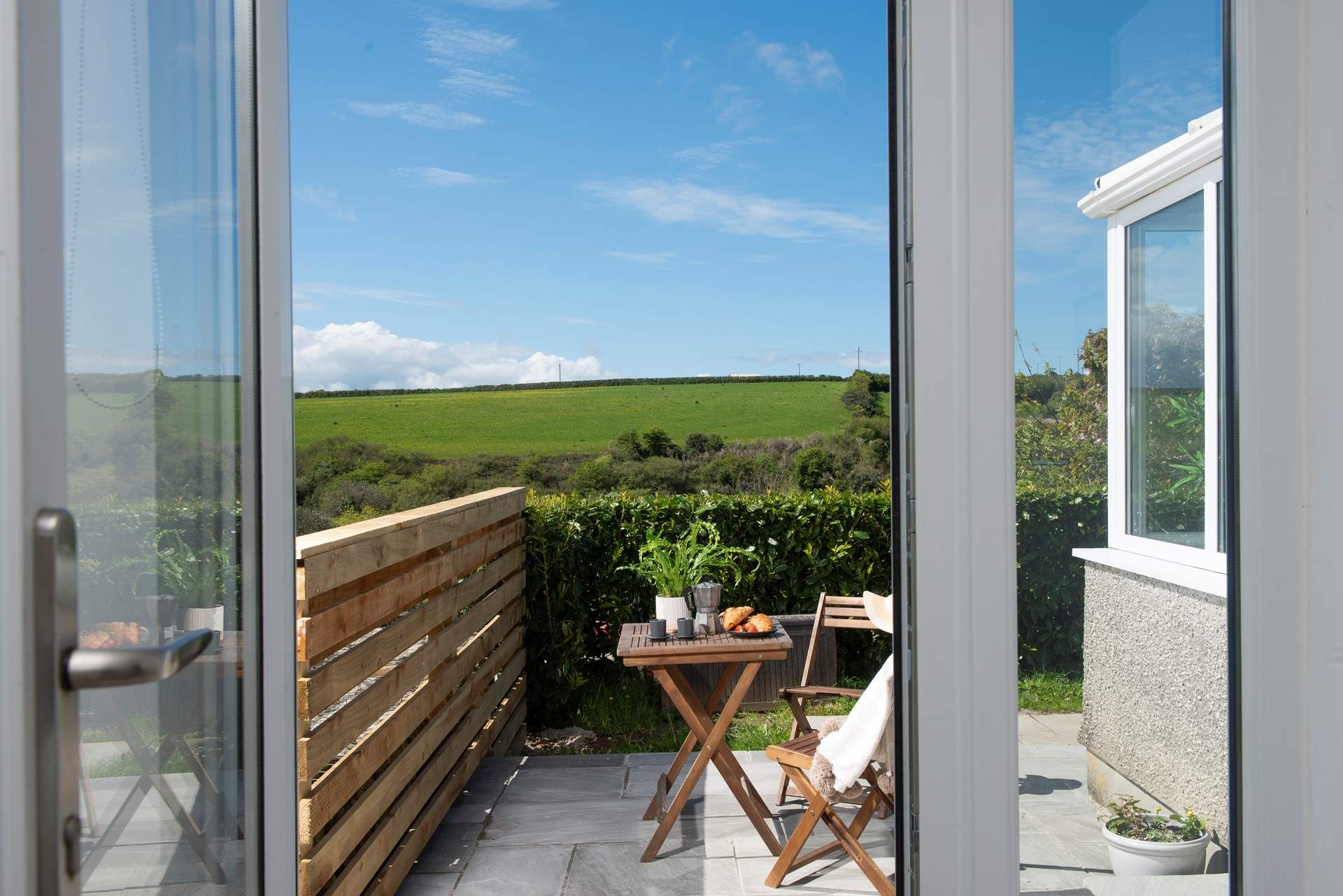 Double doors open to the sunny patio that catches the morning sun. 