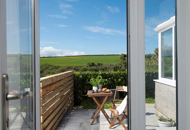 Double doors open to the sunny patio that catches the morning sun. 