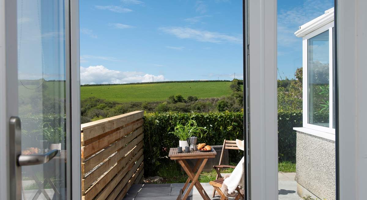 Double doors open to the sunny patio that catches the morning sun. 