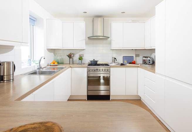 This fully equipped kitchen sits to the back of the open plan reception room.