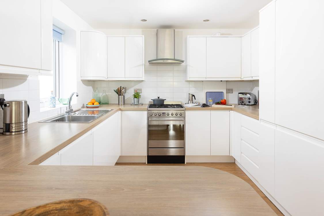 This fully equipped kitchen sits to the back of the open plan reception room.