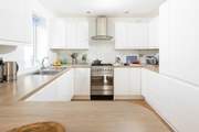 This fully equipped kitchen sits to the back of the open plan reception room.