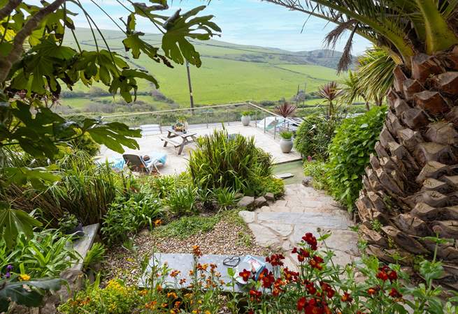 From the top patio, head down through the tropical garden to the lower terrace.