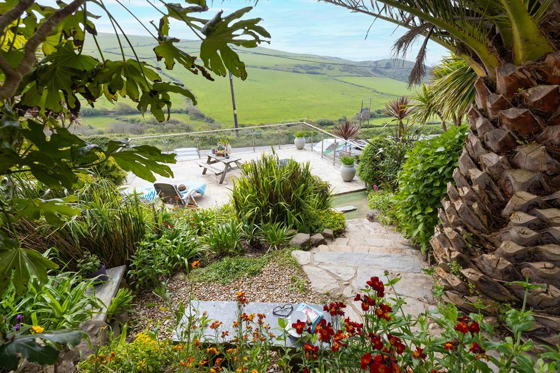 From the top patio, head down through the tropical garden to the lower terrace.