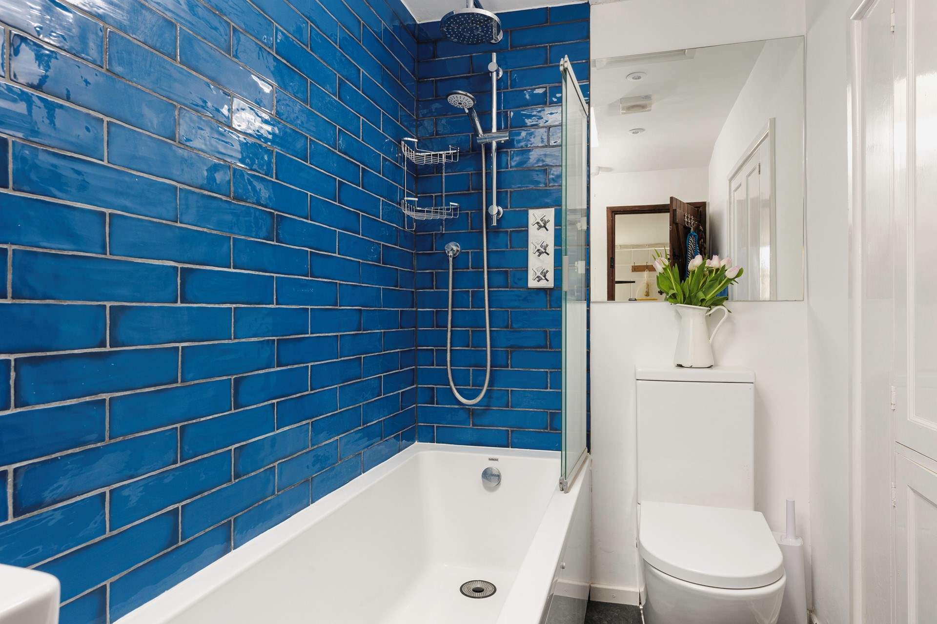 The contemporary bathroom is fresh and vibrant with beautiful blue tiles.