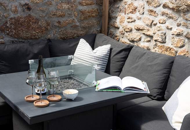 A second firepit is the centre piece of the covered outdoor dining area.