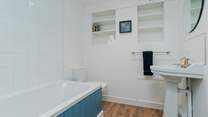 The newly renovated family bathroom to compliment the en-suite shower room. The bath has a shower over.
