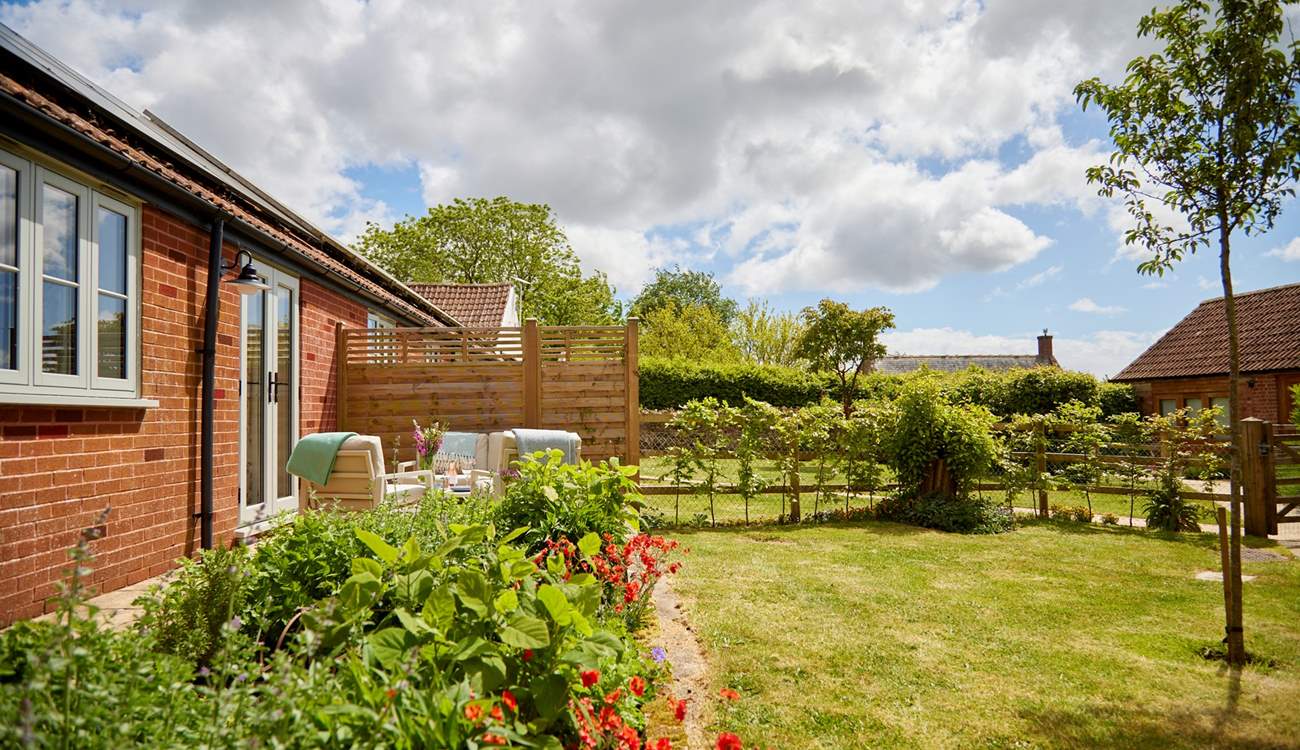 The beautiful private garden has a lovely secluded seating and dining area