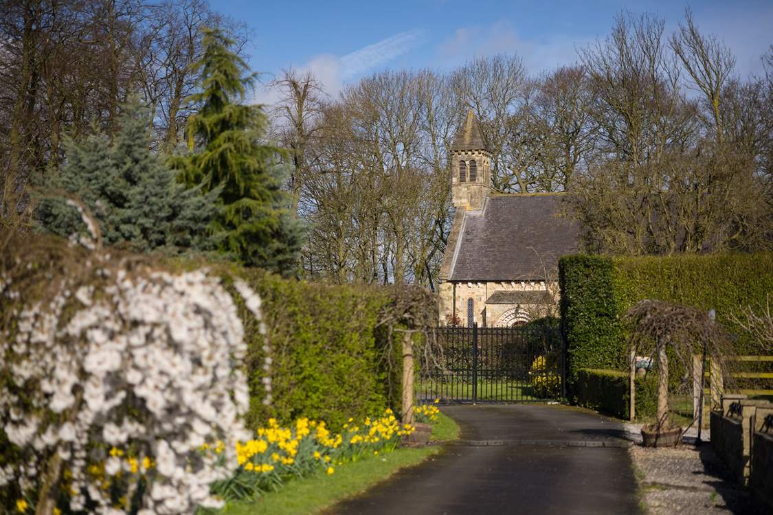 See the village church at the end of the drive.