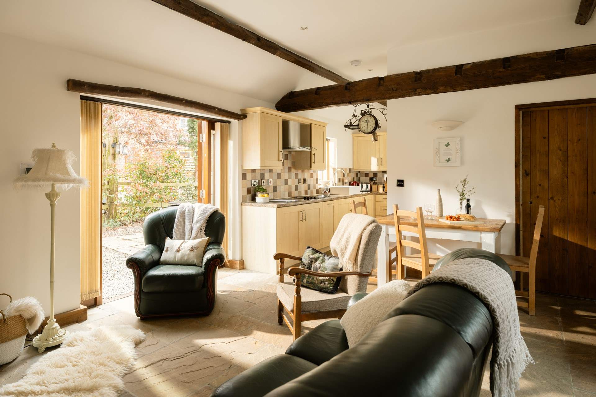 The French windows lead out to the quaint garden, which is surrounded by mature bushes and trees.