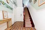 Steps in the communal hallway lead up to the front door of the apartment.