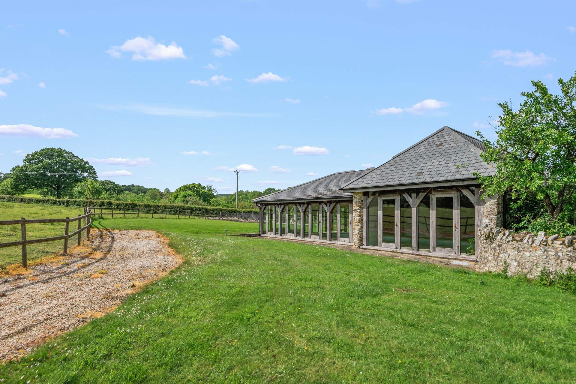 From the main barn, walk up through the side gate and follow the gravel path to the entrance of the swimming pool building.