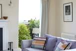 The large windows in the living-room look across to the sea.