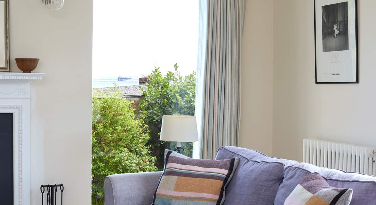 The large windows in the living-room look across to the sea.