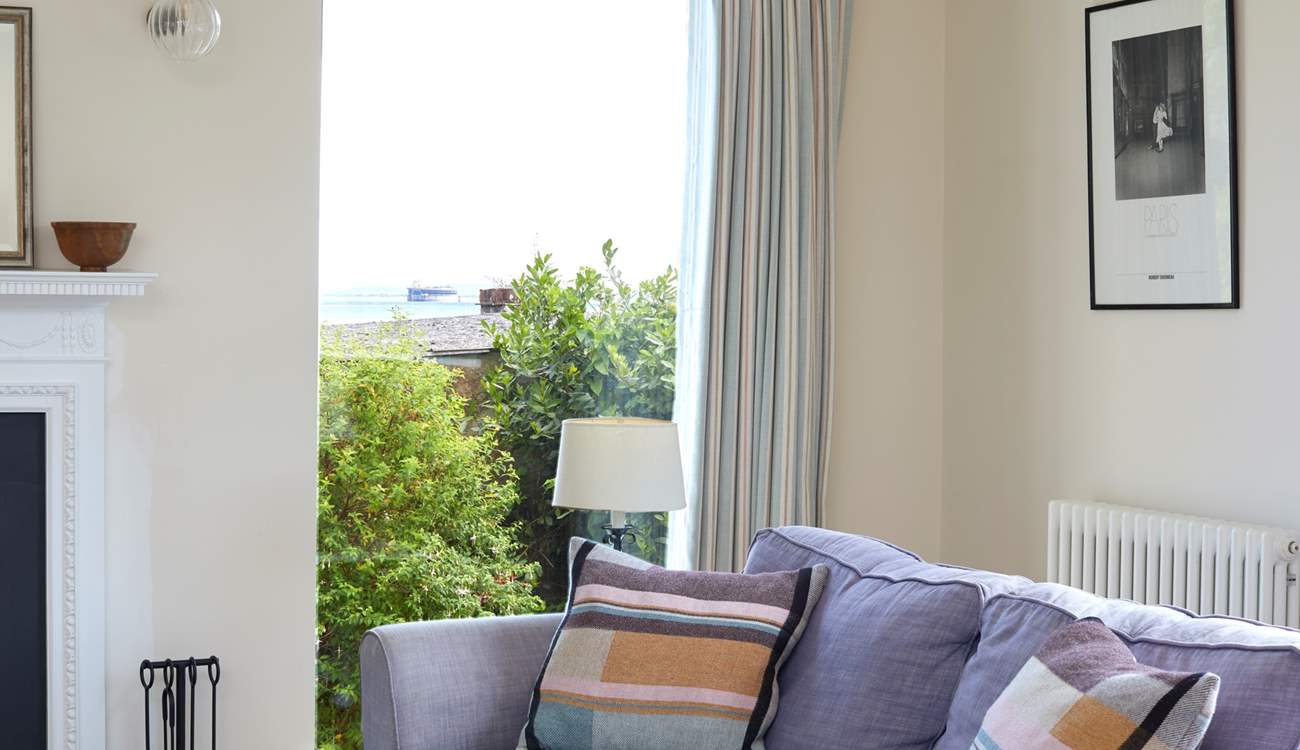 The large windows in the living-room look across to the sea.