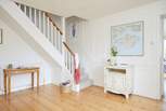 The bright hallway leads into the living space and up to the bedrooms.