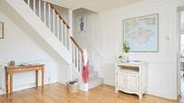 The bright hallway leads into the living space and up to the bedrooms.