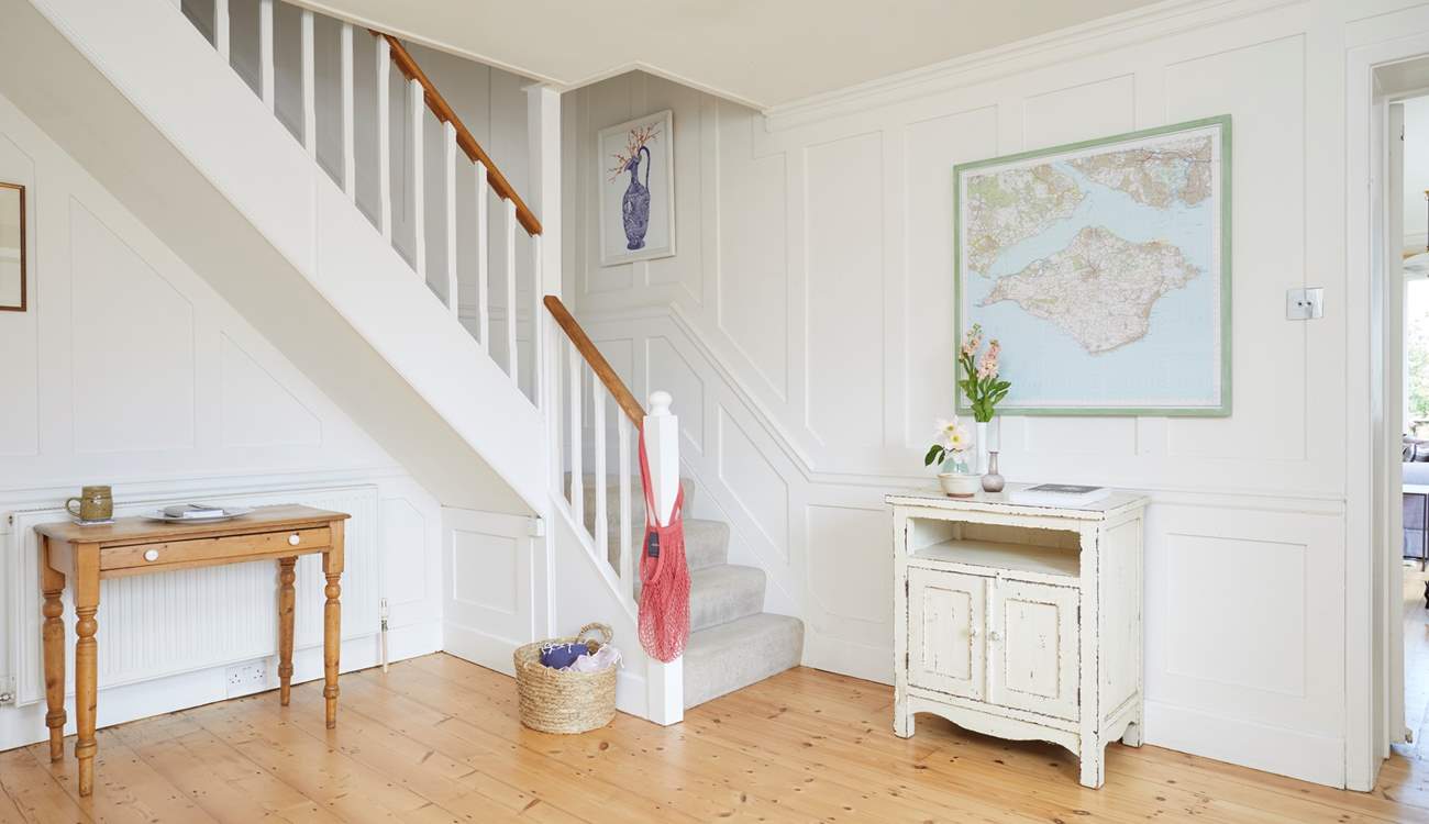 The bright hallway leads into the living space and up to the bedrooms.