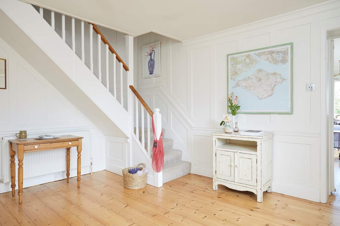 The bright hallway leads into the living space and up to the bedrooms.