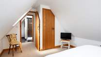 The bedroom has space to store clothes and a television.