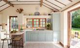 The beamed ceiling and patio doors add charm to this lovely kitchen. - Thumbnail Image