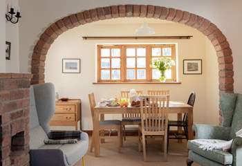 The brick arch perfectly frames the dining-table and the view to the garden.