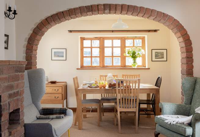 The brick arch perfectly frames the dining-table and the view to the garden.