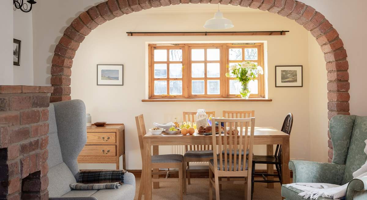 The brick arch perfectly frames the dining-table and the view to the garden.