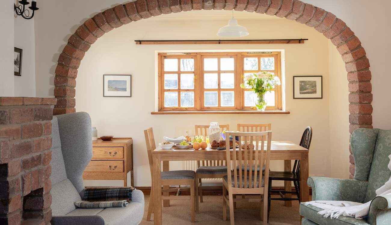 The brick arch perfectly frames the dining-table and the view to the garden.