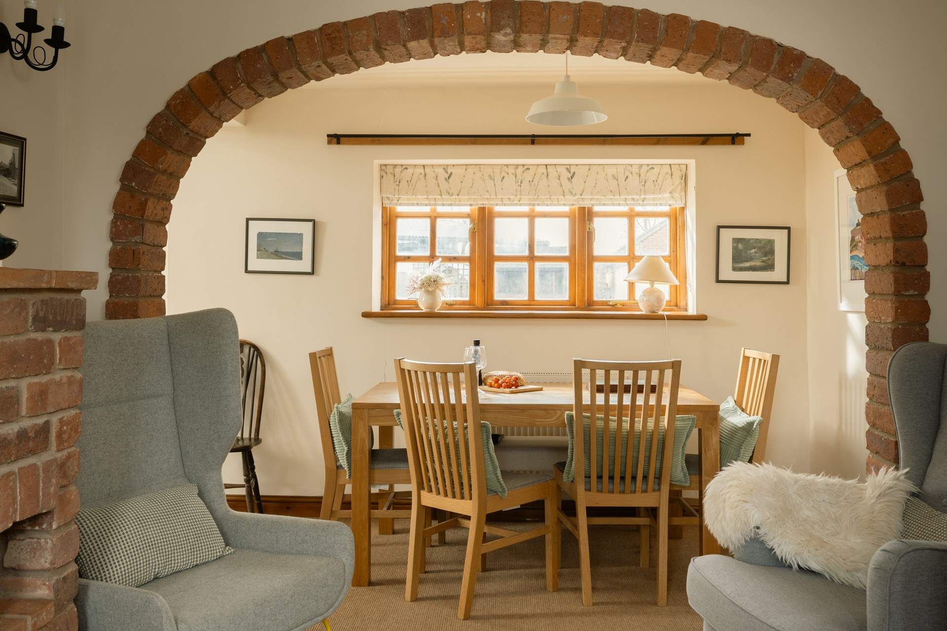 The brick arch perfectly frames the dining-table and the view to the garden.