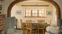 The brick arch perfectly frames the dining-table and the view to the garden.