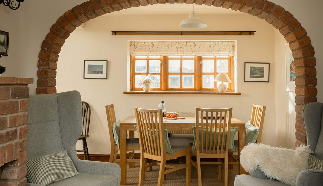 The brick arch perfectly frames the dining-table and the view to the garden.