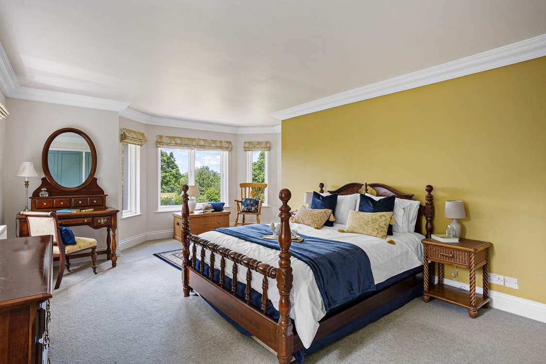 Bedroom 4 is grand and spacious with an en suite bathroom and views out over the treetops and back garden.