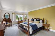 Bedroom 4 is grand and spacious with an en suite bathroom and views out over the treetops and back garden.