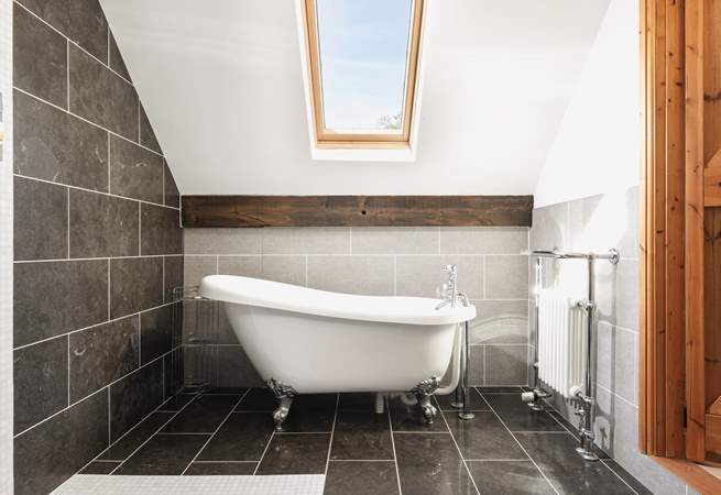 The bedroom comes complete with a delightful en suite bathroom featuring an elegant roll-top bath.
