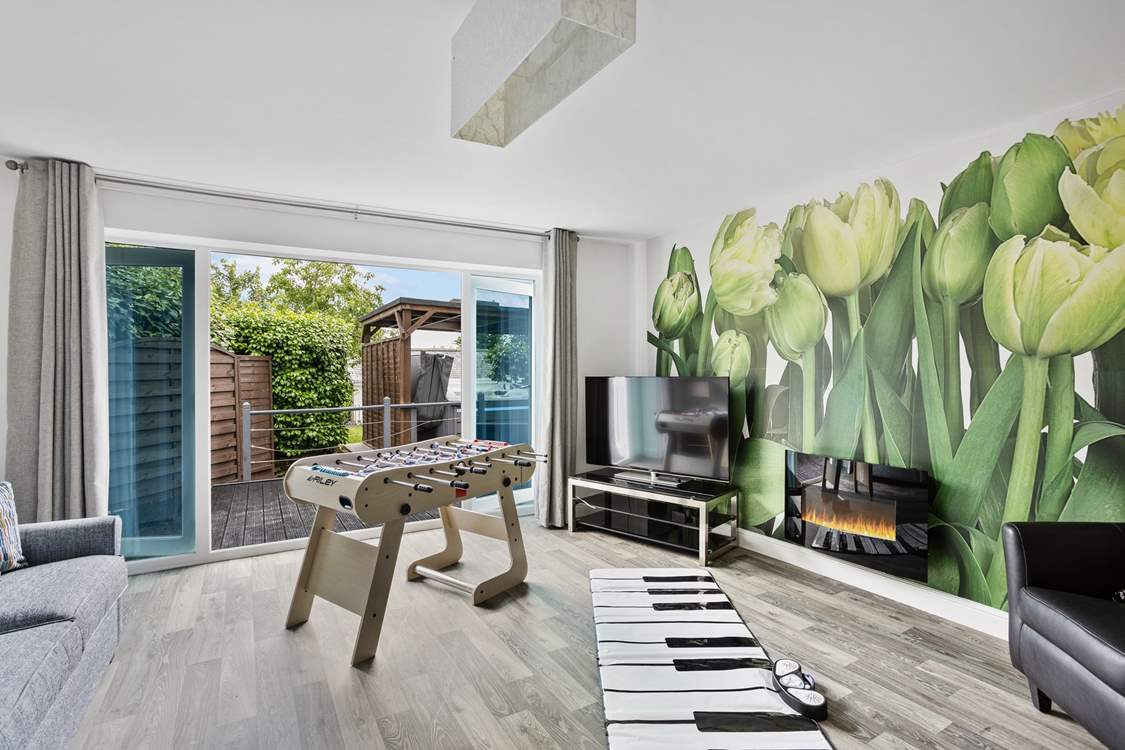 Head back to the front of the house to discover the games-room that opens up on to the hot tub decking.