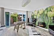 Head back to the front of the house to discover the games-room that opens up on to the hot tub decking.