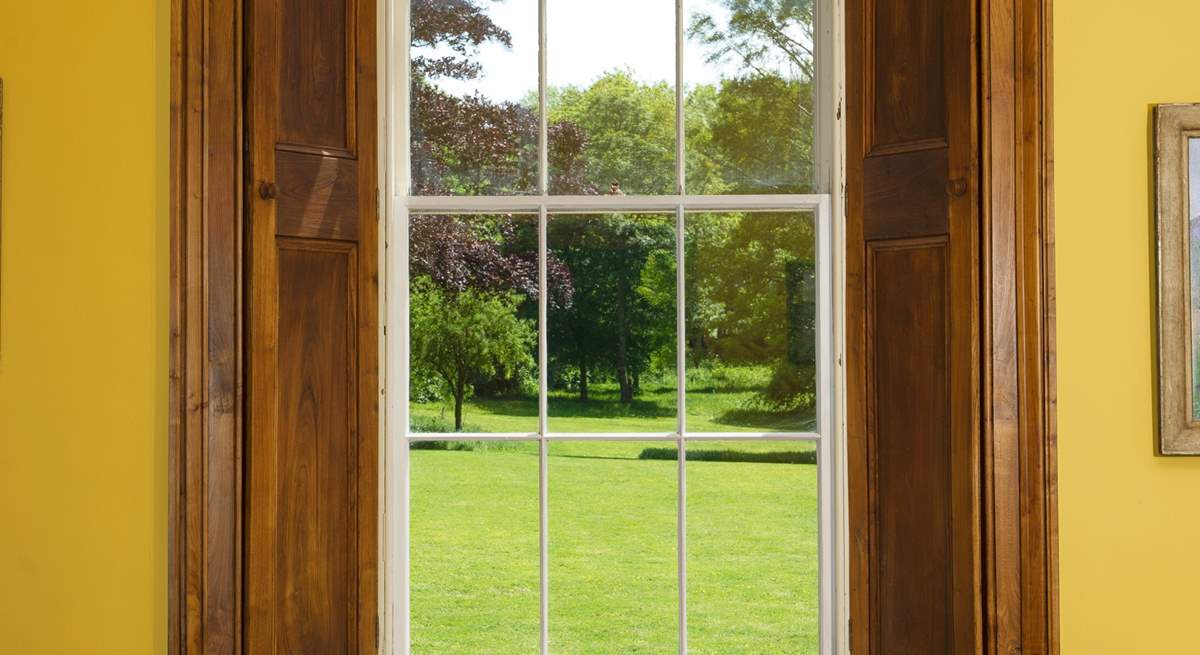 The window perfectly frames the beautiful view of the grounds..