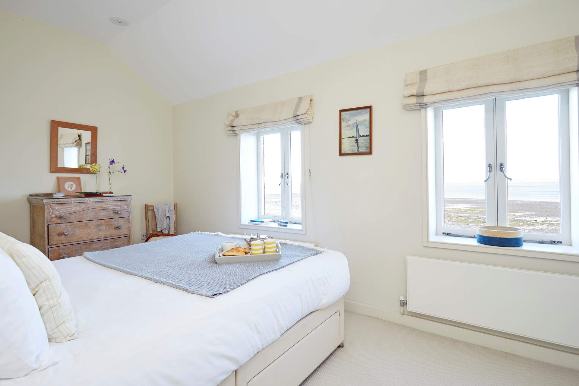 Soft bedroom interiors beautifully complement the coastal surroundings.