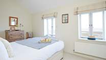 Soft bedroom interiors beautifully complement the coastal surroundings.