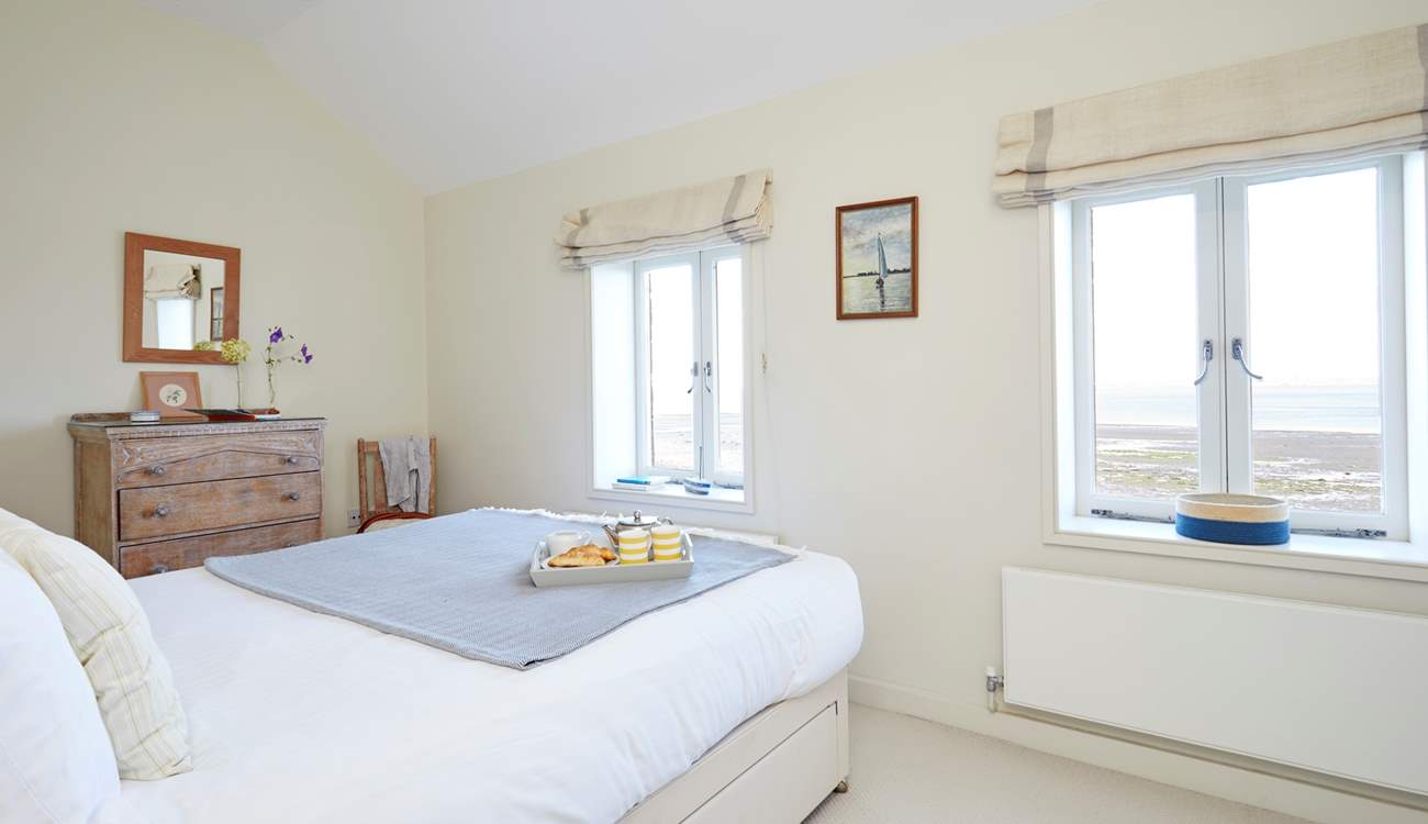 Soft bedroom interiors beautifully complement the coastal surroundings.