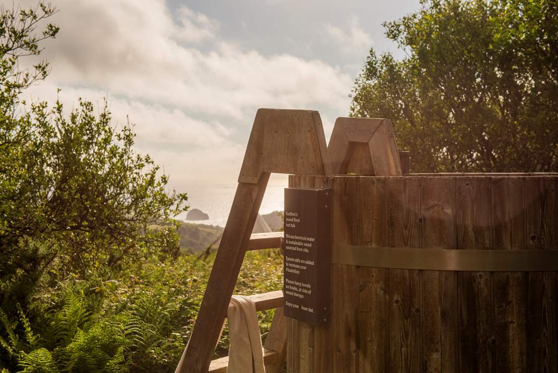 Unwind in the standing wood fired hot tub taking in the sea views.