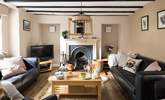 Cosy up in the sitting-room of Greystones with a traditional fireplace and beams. - Thumbnail Image