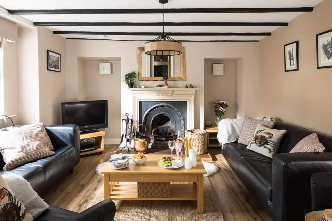 Cosy up in the sitting-room of Greystones with a traditional fireplace and beams.