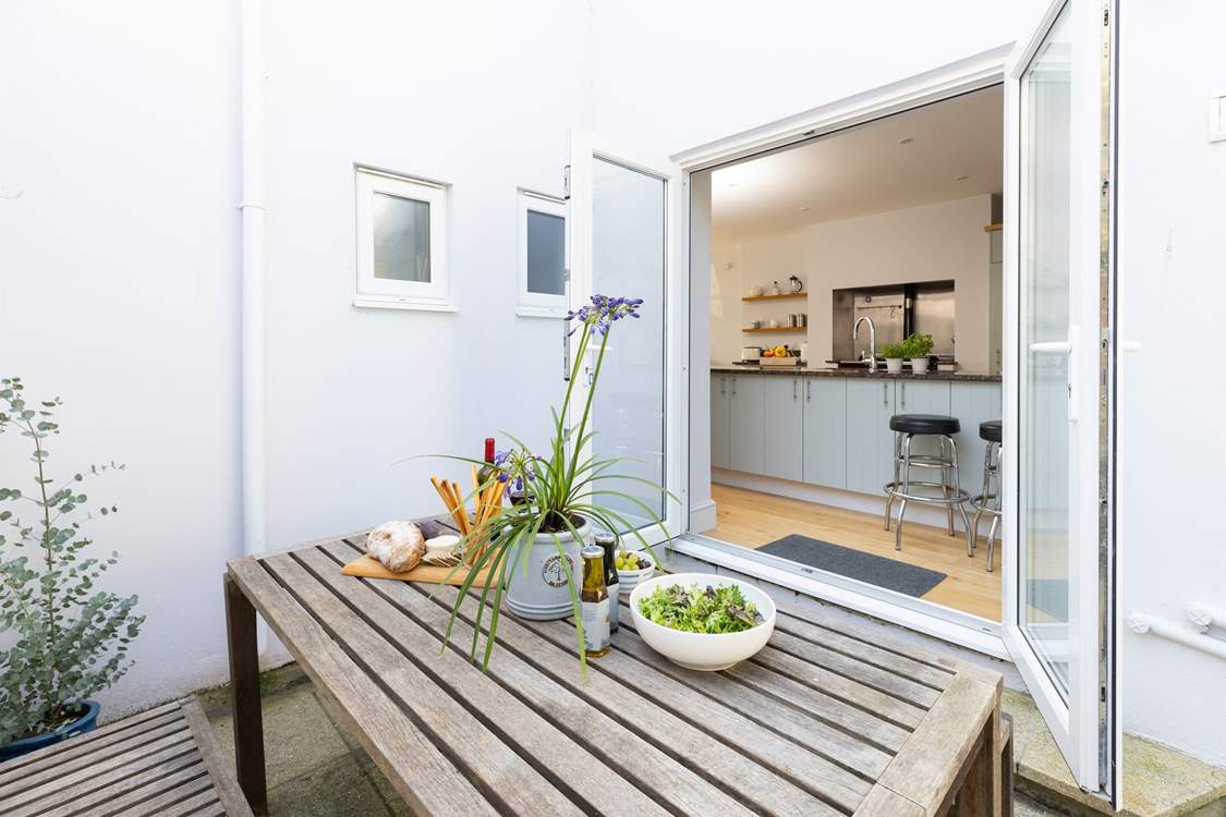 Open up the patio doors from the kitchen/diner to courtyard.