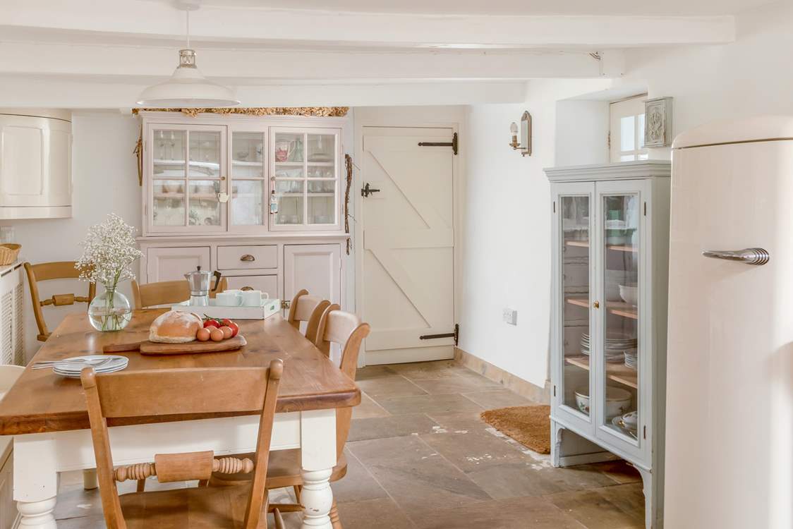 The kitchen/diner leads through to the sitting-rooms, the stairs to the bedrooms and a front door out to the porch.