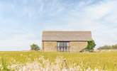 The barn appears at the end of a track, off a quiet country lane, rising slightly above the surrounding fields - Thumbnail Image