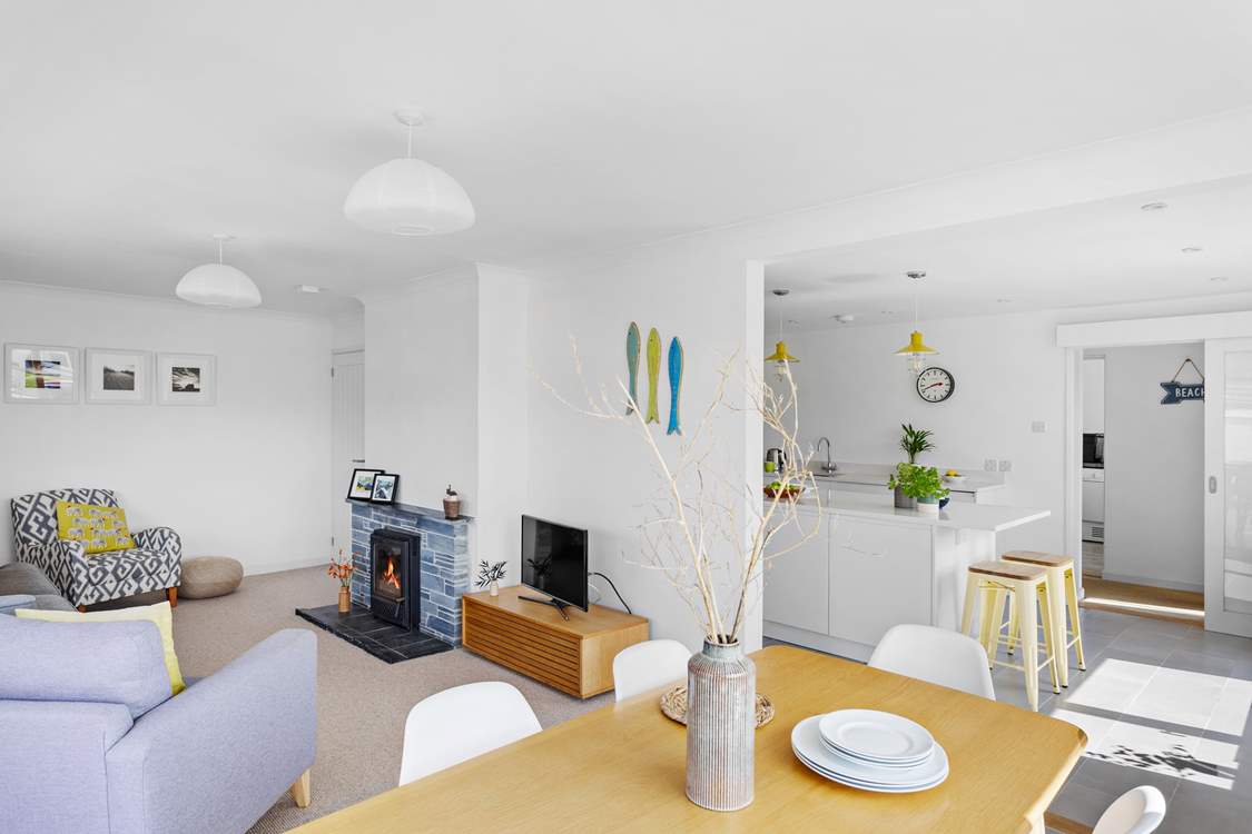 Sink back on the sofa by the cosy focal wood-burner within this modern airy space.